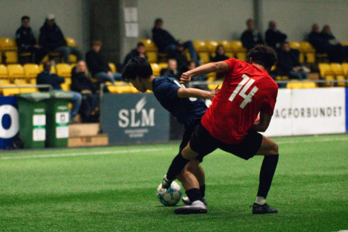 To spillere som kjemper om en ball mens college-trenere ser på Keystone Sports College Soccer Showcase